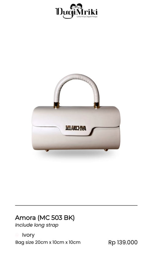 An ivory structured handbag with a long curved top handle, shown on a white background with product details below. The brand name 'Dugi Mriki' is visible at the top, and the model name 'Amora' is listed at the bottom.