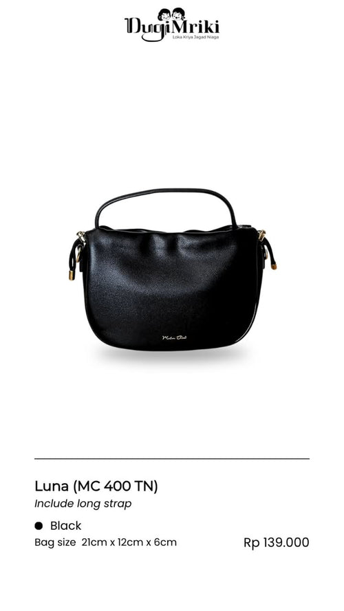 A black leather handbag with a top handle and gold-tone hardware, shown on a white background with product details below. The brand name 'Dugi Mriki' is visible at the top, and the bag model is labeled 'Luna (MC 400 TN)'.