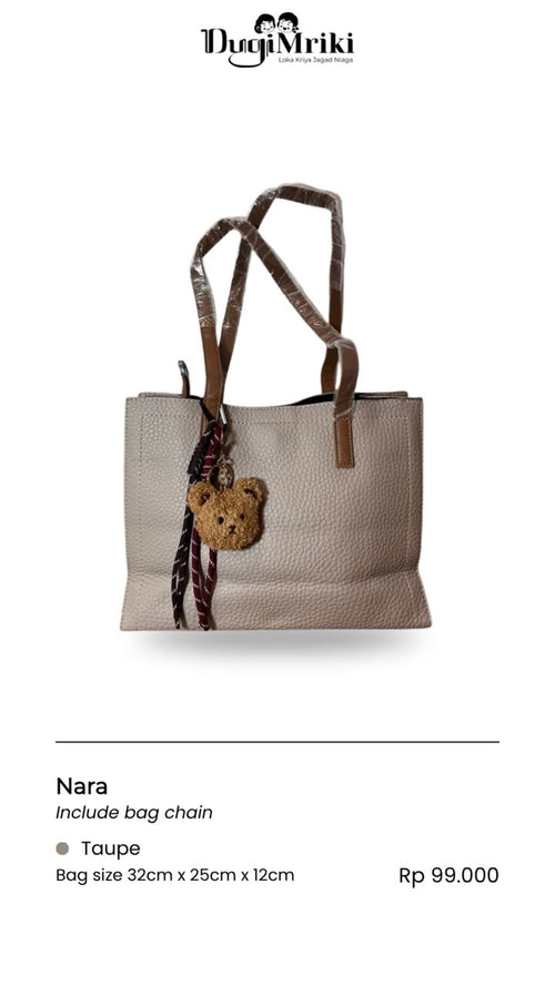 A taupe pebbled leather tote bag by DugiMriki, featuring brown leather handles, a hanging teddy bear charm, and a patterned bag chain. The image includes product specifications and pricing text below on a white background.