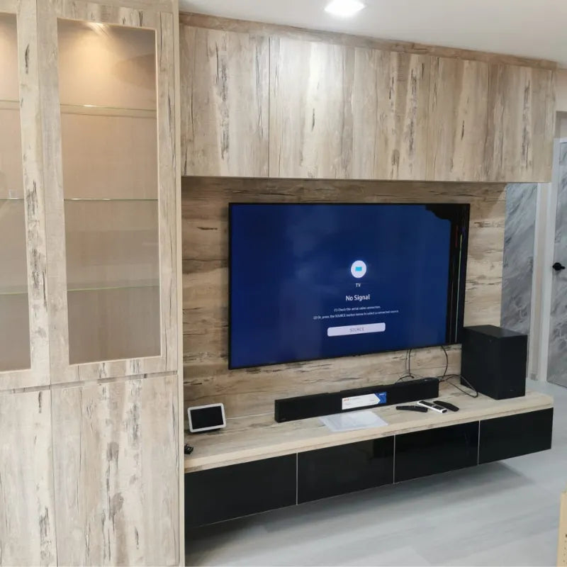 Modern living room with wooden wall paneling, TV, and entertainment system.